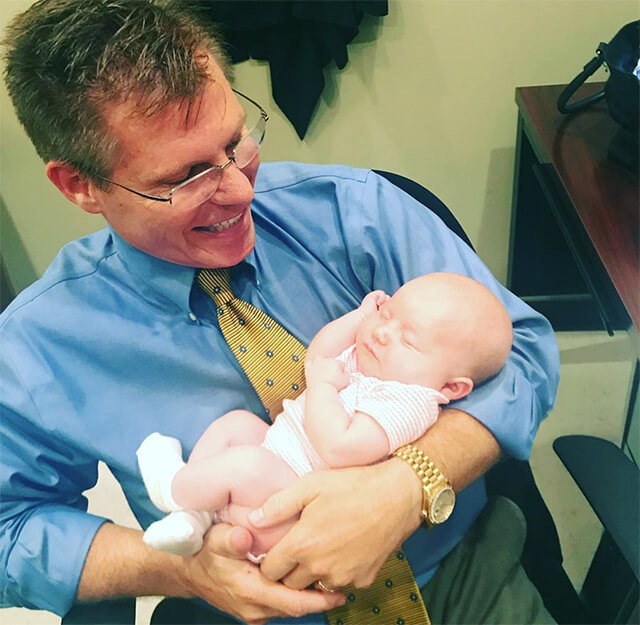 NuBody Concepts plastic surgeon Dr Rosdeutscher with a newborn staff baby