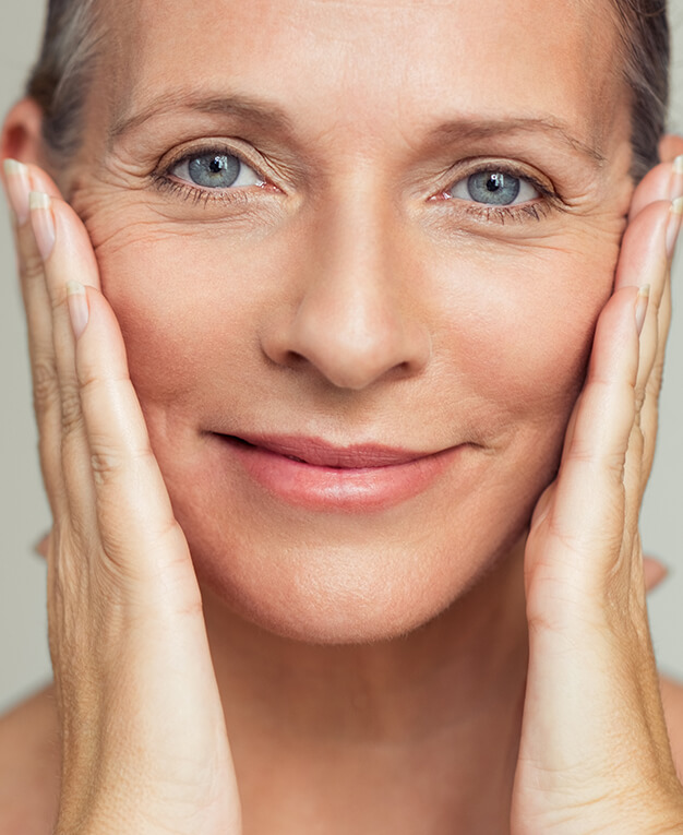 Facetite middle aged woman holding her face in both hands