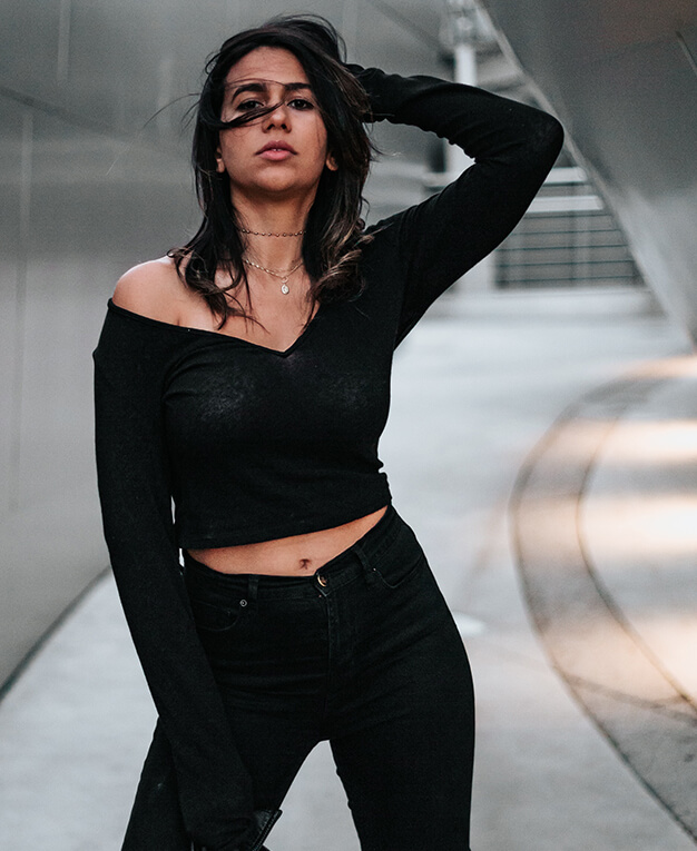 Renuvion stylish woman in black wearing gloves twirling her hair